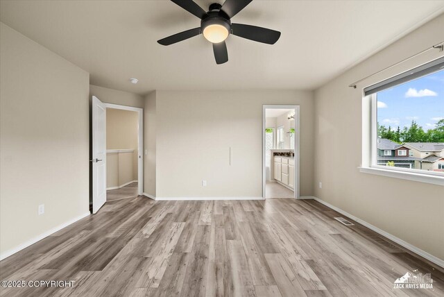 2987 Morgan Loop, Anchorage, AK 99516 - unfurnished bedroom featuring wood finished floors, connected bathroom, and a ceiling fan