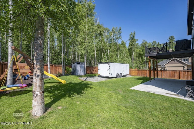 13378 Rosser Dr, Eagle River, AK 99577 - fenced backyard with a playground, a patio area, and a storage unit