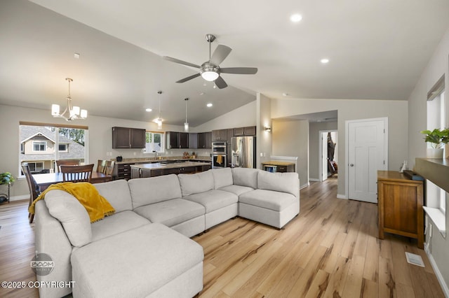 13378 Rosser Dr, Eagle River, AK 99577 - living area with vaulted ceiling, light wood-type flooring, recessed lighting, ceiling fan, and a chandelier