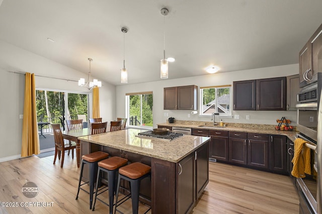 13378 Rosser Dr, Eagle River, AK 99577 - kitchen with light wood-type flooring, a chandelier, a kitchen bar, light stone countertops, and vaulted ceiling