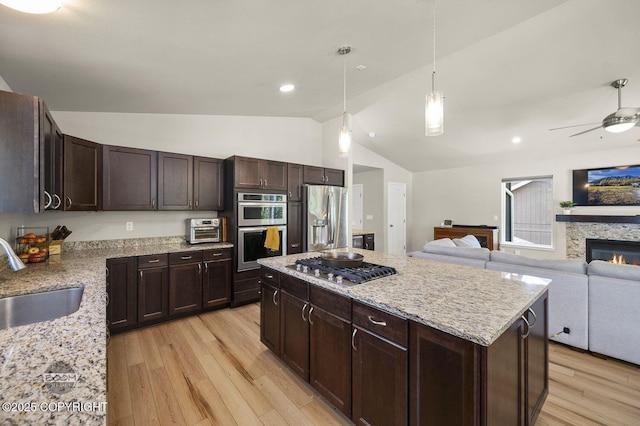 13378 Rosser Dr, Eagle River, AK 99577 - kitchen featuring appliances with stainless steel finishes, lofted ceiling, light wood-type flooring, a ceiling fan, and light stone countertops