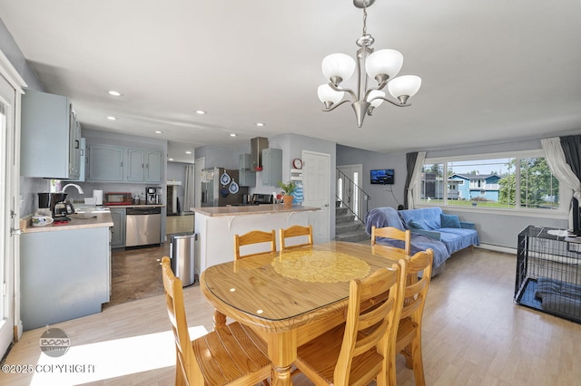 8100 E 20th Ave, Anchorage, AK 99504 - dining room featuring a chandelier, light wood finished floors, stairway, a baseboard radiator, and recessed lighting