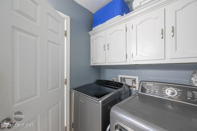 8100 E 20th Ave, Anchorage, AK 99504 - laundry room with washer and clothes dryer, cabinet space, and a textured ceiling