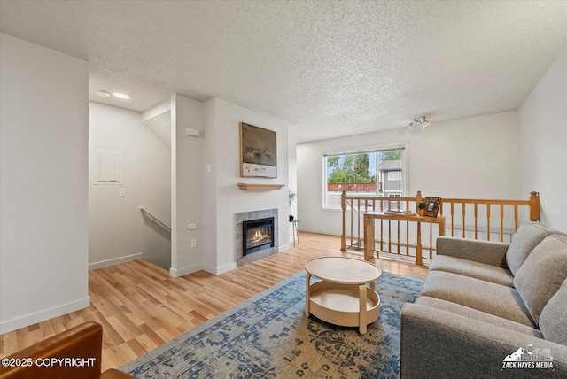 943 E 12th Ave # 6, Anchorage, AK 99501 - living room with a textured ceiling, wood finished floors, baseboards, and a tiled fireplace