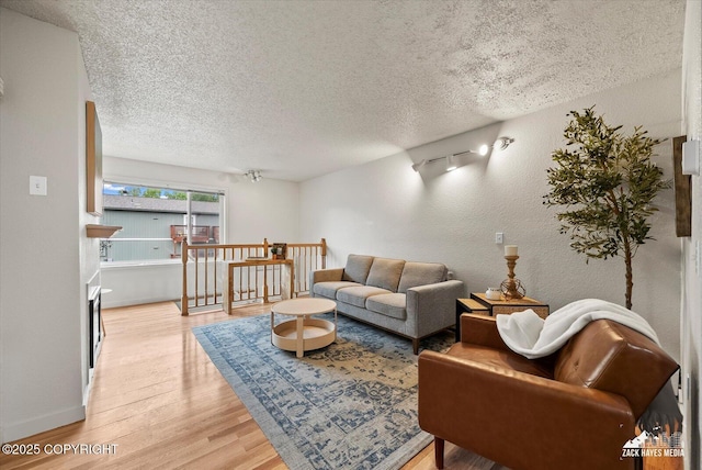943 E 12th Ave # 6, Anchorage, AK 99501 - living area featuring light wood-type flooring, a textured ceiling, a textured wall, and baseboards