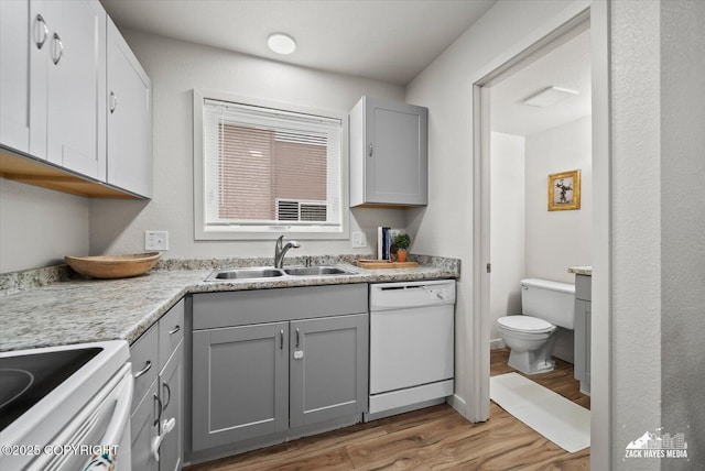 943 E 12th Ave # 6, Anchorage, AK 99501 - kitchen with white dishwasher, a sink, gray cabinetry, light wood-style floors, and light countertops