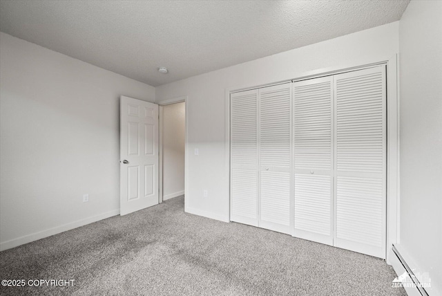 943 E 12th Ave # 6, Anchorage, AK 99501 - unfurnished bedroom with a baseboard heating unit, carpet flooring, a textured ceiling, a closet, and baseboards