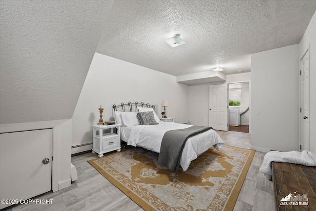 943 E 12th Ave # 6, Anchorage, AK 99501 - bedroom with a textured ceiling, a baseboard radiator, washer / dryer, and light wood-type flooring