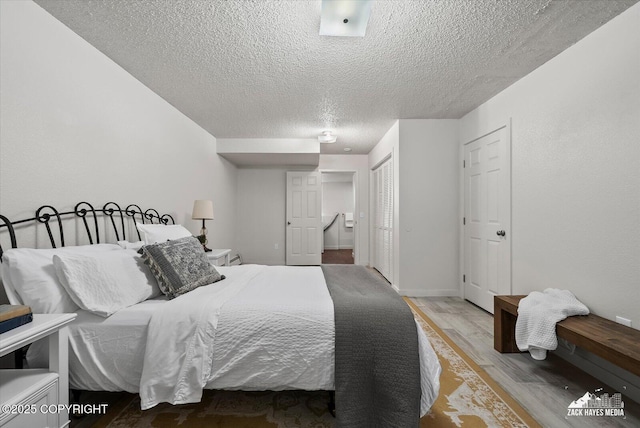 943 E 12th Ave # 6, Anchorage, AK 99501 - bedroom featuring wood finished floors, a textured ceiling, and a closet