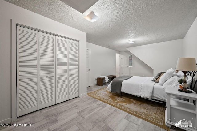 943 E 12th Ave # 6, Anchorage, AK 99501 - bedroom with wood finished floors, a textured ceiling, a closet, and baseboards