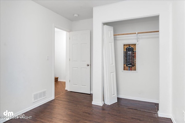 5621 Sapphire Loop Unit 18A, Anchorage, AK 99504 - unfurnished bedroom with a closet, dark wood-style flooring, and baseboards
