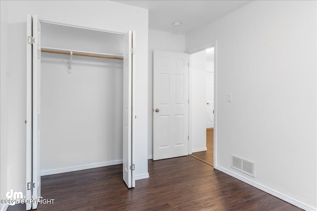 5621 Sapphire Loop Unit 18A, Anchorage, AK 99504 - unfurnished bedroom with a closet, dark wood-type flooring, and baseboards