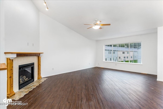 5621 Sapphire Loop Unit 18A, Anchorage, AK 99504 - unfurnished living room featuring ceiling fan, vaulted ceiling, a glass covered fireplace, dark wood-style flooring, and baseboards