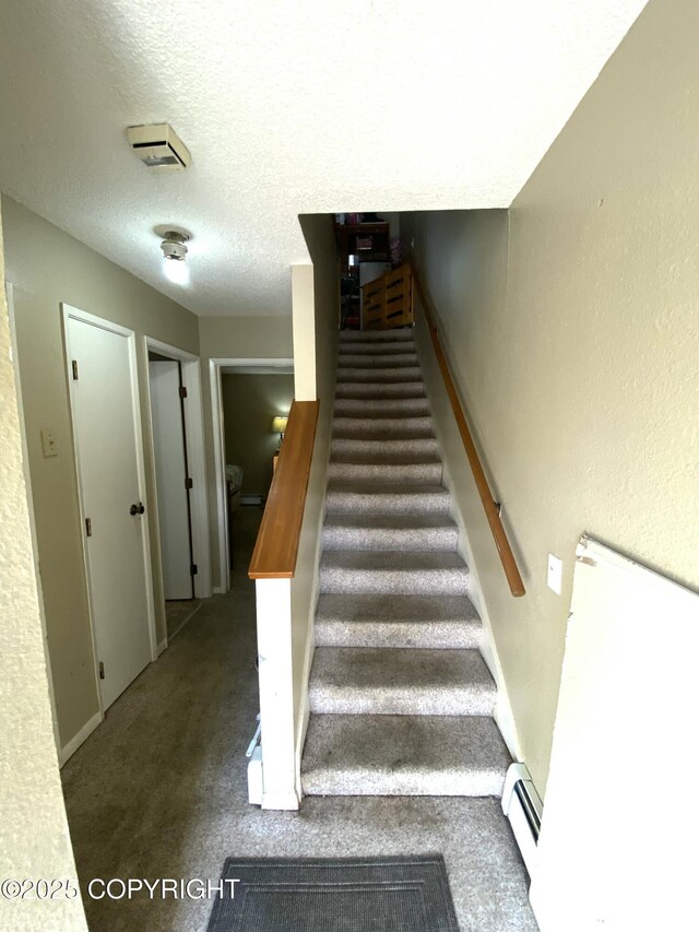 7766 Boundary Ave # G3, Anchorage, AK 99504 - stairs featuring baseboard heating, carpet, and a textured ceiling