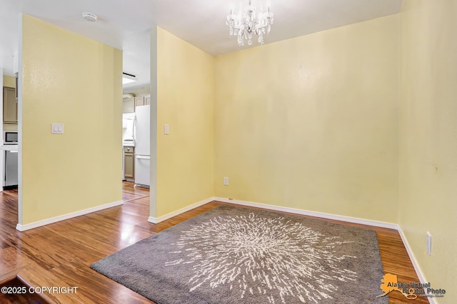 2003 Jamestown Cir, Anchorage, AK 99507 - unfurnished room with wood finished floors, a chandelier, and a smoke detector