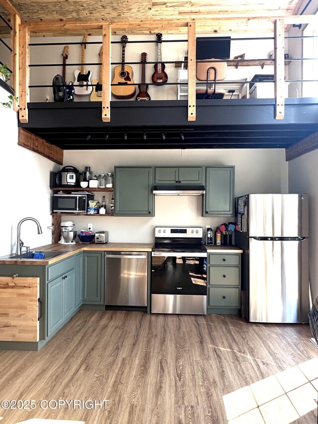 36339 Maria Rd, Homer, AK 99603 - kitchen with appliances with stainless steel finishes, light wood-style floors, under cabinet range hood, and open shelves