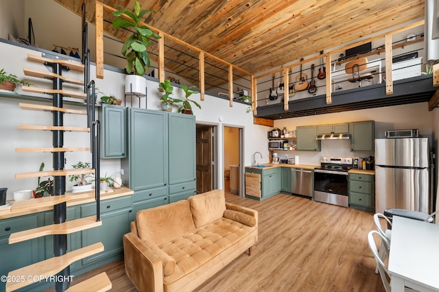 36339 Maria Rd, Homer, AK 99603 - kitchen featuring open shelves, appliances with stainless steel finishes, under cabinet range hood, a high ceiling, and light wood-style flooring