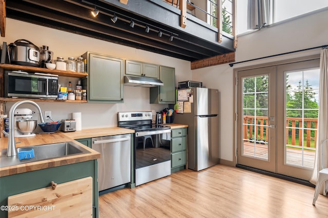 36339 Maria Rd, Homer, AK 99603 - kitchen with green cabinetry, appliances with stainless steel finishes, wood counters, under cabinet range hood, and light wood-style flooring