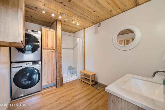 36339 Maria Rd, Homer, AK 99603 - laundry room with stacked washer / drying machine, track lighting, wood ceiling, and light wood-style flooring