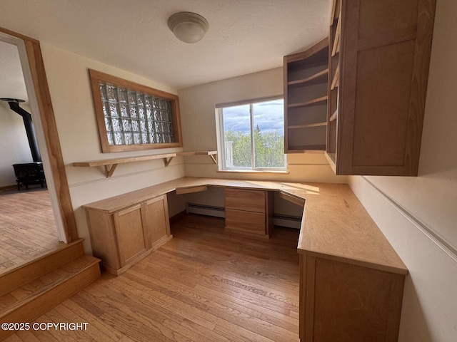705 W Fairview Ave, Homer, AK 99603 - unfurnished office with built in study area, light wood-style floors, a wood stove, and a baseboard radiator