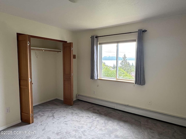 705 W Fairview Ave, Homer, AK 99603 - unfurnished bedroom featuring a baseboard heating unit, light colored carpet, and a closet