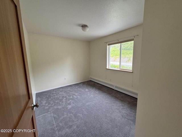 705 W Fairview Ave, Homer, AK 99603 - spare room featuring a baseboard heating unit, dark carpet, a textured ceiling, and baseboards