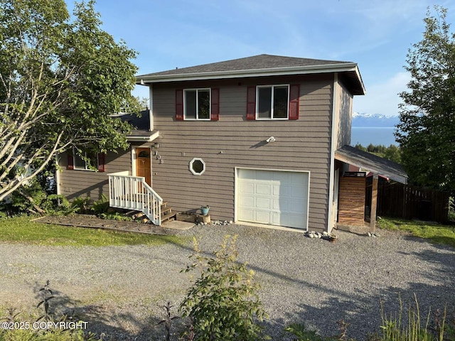 705 W Fairview Ave, Homer, AK 99603 - back of property with an attached garage, gravel driveway, and a shingled roof