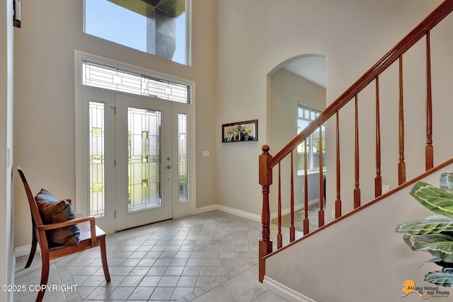 2842 Ensign Dr, Anchorage, AK 99515 - foyer entrance with a high ceiling, arched walkways, stairs, and light tile patterned floors