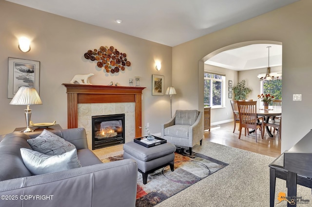 2842 Ensign Dr, Anchorage, AK 99515 - living area with arched walkways, a fireplace, wood finished floors, and a chandelier