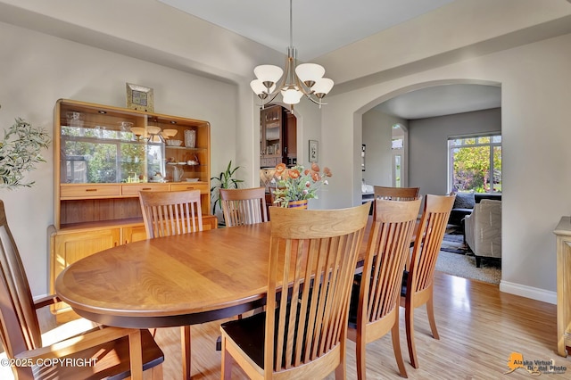 2842 Ensign Dr, Anchorage, AK 99515 - dining room featuring arched walkways, light wood-style floors, and a chandelier