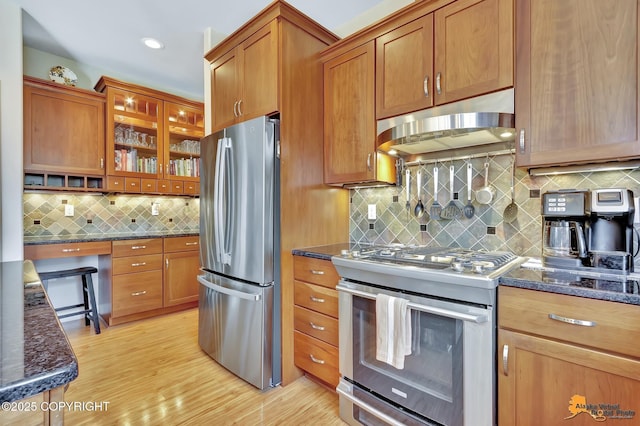 2842 Ensign Dr, Anchorage, AK 99515 - kitchen with appliances with stainless steel finishes, under cabinet range hood, backsplash, and brown cabinets