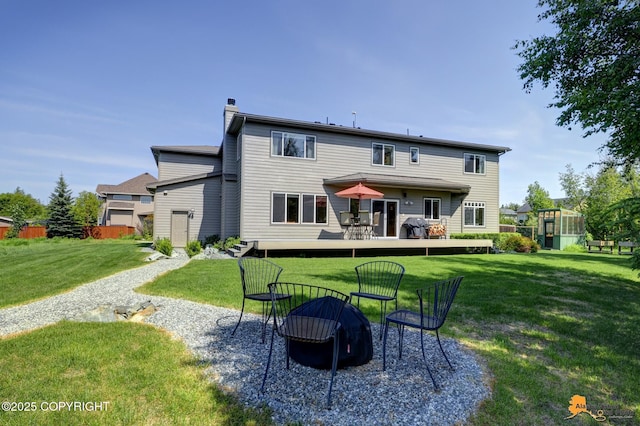 2842 Ensign Dr, Anchorage, AK 99515 - rear view of property with an outdoor fire pit, a chimney, a yard, and a greenhouse