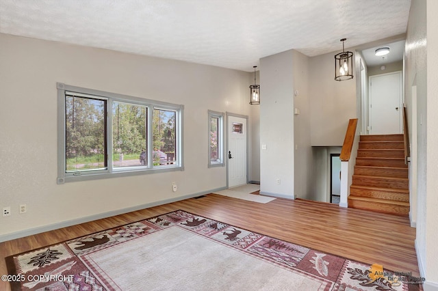 3091 N Longspur Dr, Wasilla, AK 99654 - unfurnished living room with wood finished floors, stairway, and a textured ceiling