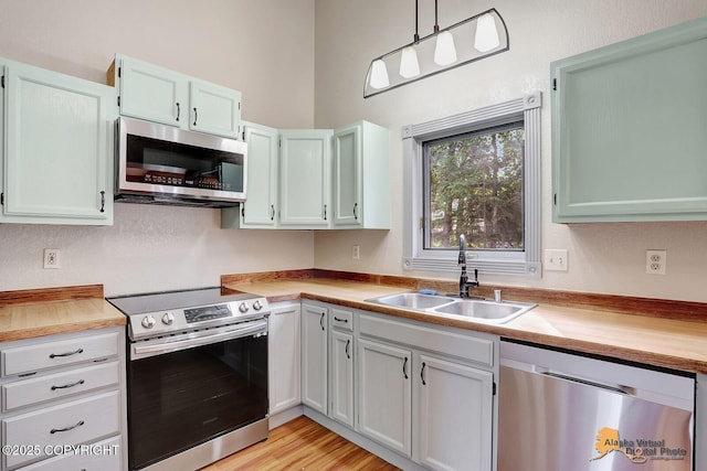 3091 N Longspur Dr, Wasilla, AK 99654 - kitchen featuring appliances with stainless steel finishes, light countertops, decorative light fixtures, and light wood-type flooring