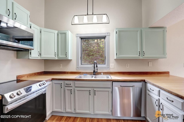 3091 N Longspur Dr, Wasilla, AK 99654 - kitchen featuring stainless steel appliances, light countertops, decorative light fixtures, and light wood-style floors