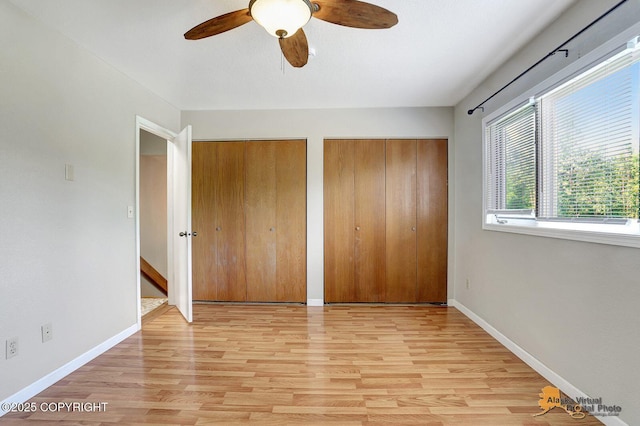 3091 N Longspur Dr, Wasilla, AK 99654 - unfurnished bedroom with light wood-type flooring, multiple closets, and a ceiling fan