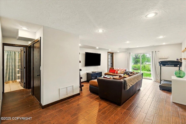51137 Nanook Cir, Nikiski/North Kenai, AK 99611 - living room featuring dark wood-type flooring, a textured ceiling, recessed lighting, and baseboards