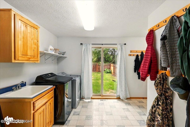 51137 Nanook Cir, Nikiski/North Kenai, AK 99611 - laundry room featuring a sink, washing machine and dryer, light floors, a textured ceiling, and baseboards