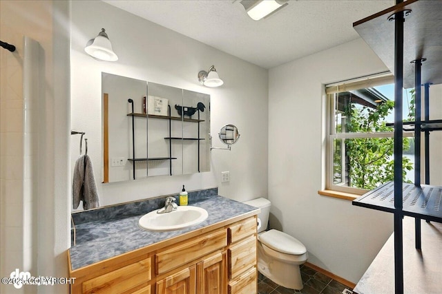 51137 Nanook Cir, Nikiski/North Kenai, AK 99611 - bathroom featuring toilet, vanity, baseboards, tile patterned flooring, and a tile shower