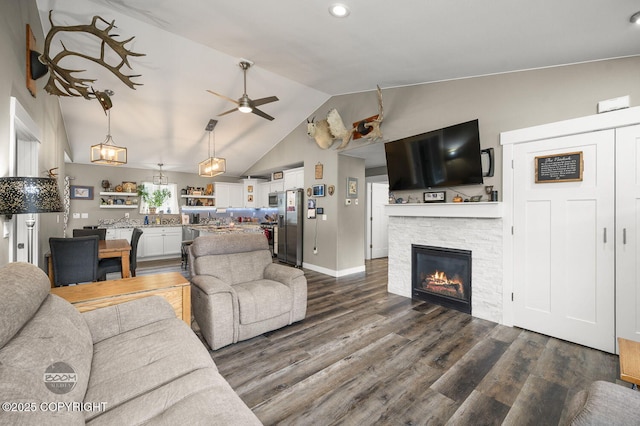 1169 W Trumpeter Swan Dr, Wasilla, AK 99623 - living room featuring lofted ceiling, dark wood finished floors, ceiling fan, a stone fireplace, and baseboards