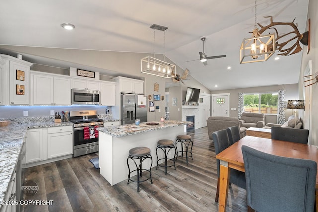 1169 W Trumpeter Swan Dr, Wasilla, AK 99623 - kitchen featuring stainless steel appliances, a ceiling fan, open floor plan, white cabinets, and high vaulted ceiling