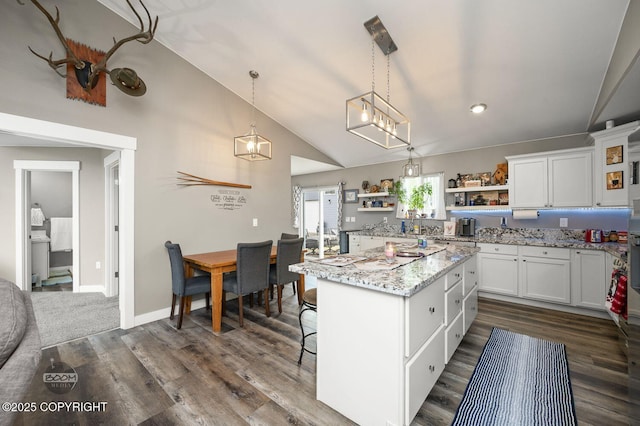 1169 W Trumpeter Swan Dr, Wasilla, AK 99623 - kitchen featuring open shelves, lofted ceiling, white cabinets, a center island, and light stone counters