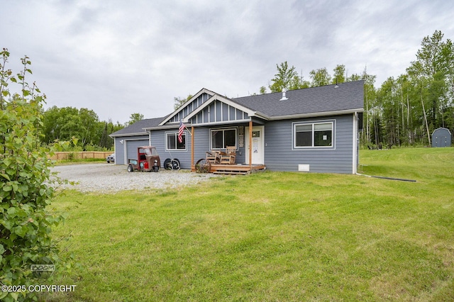 1169 W Trumpeter Swan Dr, Wasilla, AK 99623 - rear view of house featuring board and batten siding, an attached garage, a lawn, driveway, and a porch