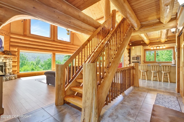 3108 Misty Mountain Rd, Eagle River, AK 99577 - staircase featuring a wood ceiling with exposed beams, tile patterned flooring, and rustic walls