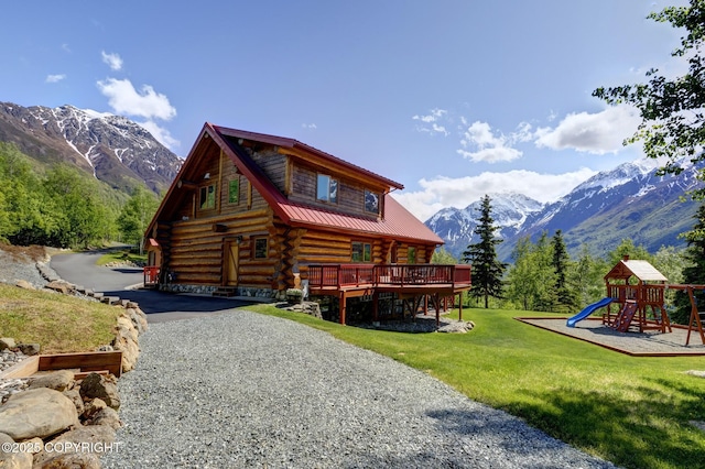 3108 Misty Mountain Rd, Eagle River, AK 99577 - rear view of house with log siding, a yard, a playground, a deck with mountain view, and a metal roof