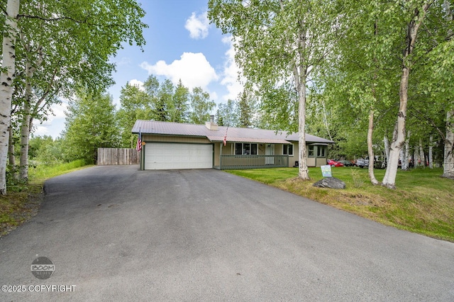 10010 Colville St, Eagle River, AK 99577 - view of front of home with an attached garage, a chimney, asphalt driveway, and a metal roof