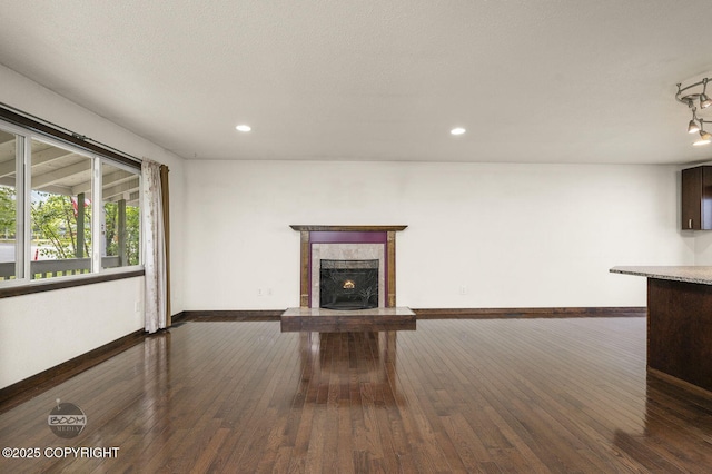 10010 Colville St, Eagle River, AK 99577 - unfurnished living room with a fireplace with raised hearth, dark wood-style flooring, and recessed lighting