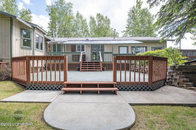 10010 Colville St, Eagle River, AK 99577 - back of property with a deck, a metal roof, and a patio