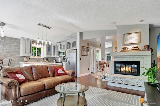 2309 Success Dr, Anchorage, AK 99504 - living room with dark wood finished floors, a textured ceiling, lofted ceiling, and a fireplace