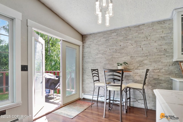 2309 Success Dr, Anchorage, AK 99504 - dining room featuring a textured ceiling, wood finished floors, healthy amount of natural light, and a chandelier